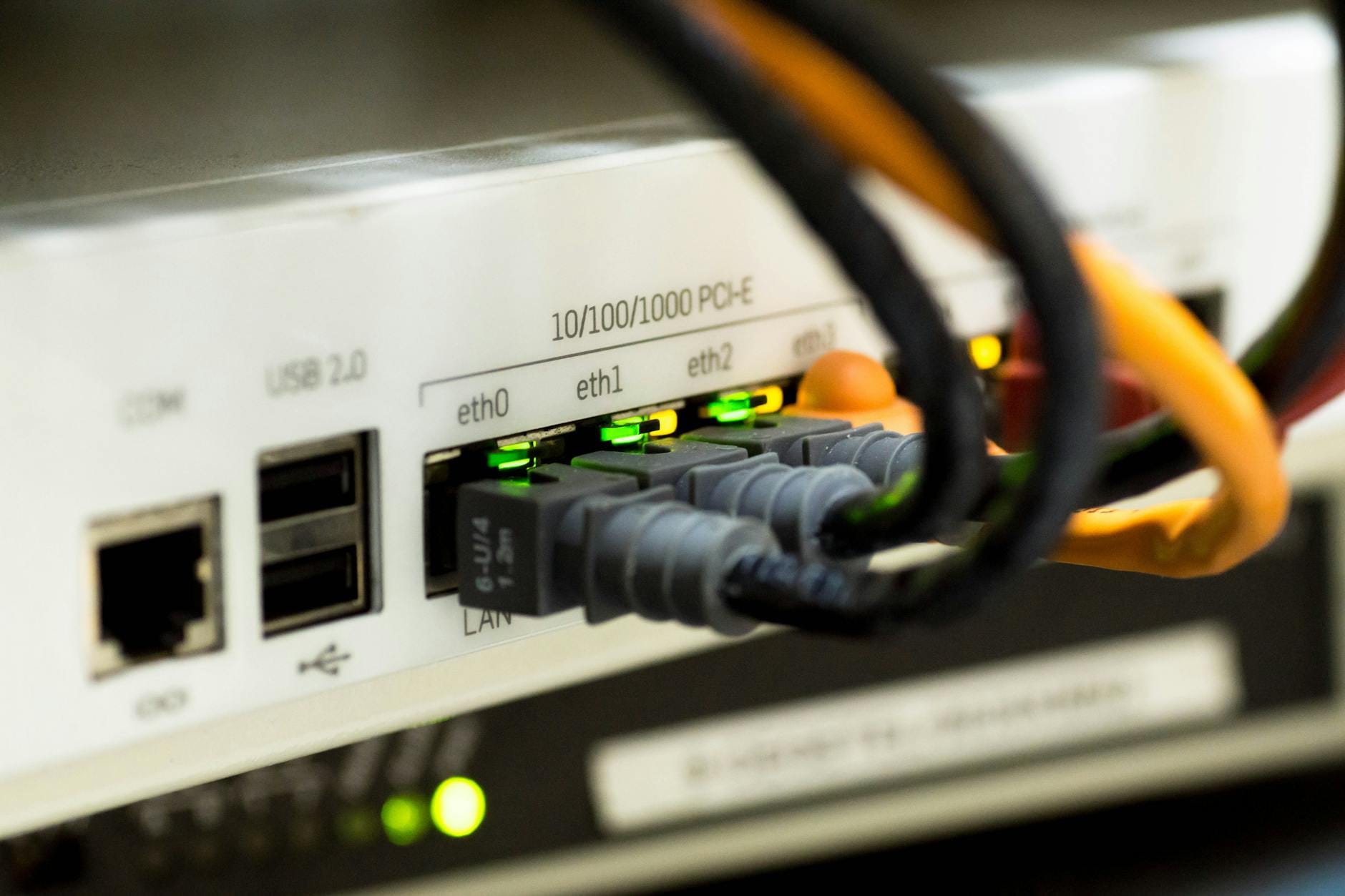 Jak budować spójny ekosystem IoT w rozproszonych obiektach przemysłowych bez wymiany całej infrastruktury Zbliżenie kabli ethernet podłączonych do przemysłowego routera IoT